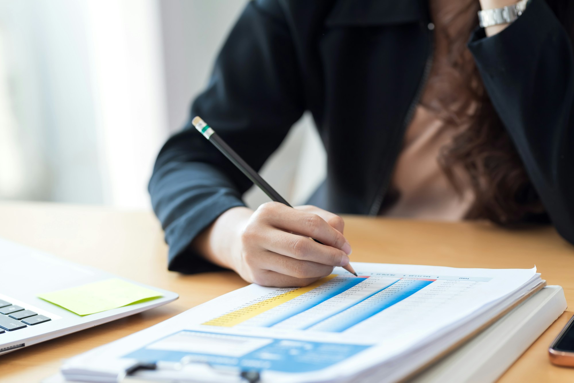 Businesswoman sitting at the work to analyze accounting using graph in the office.